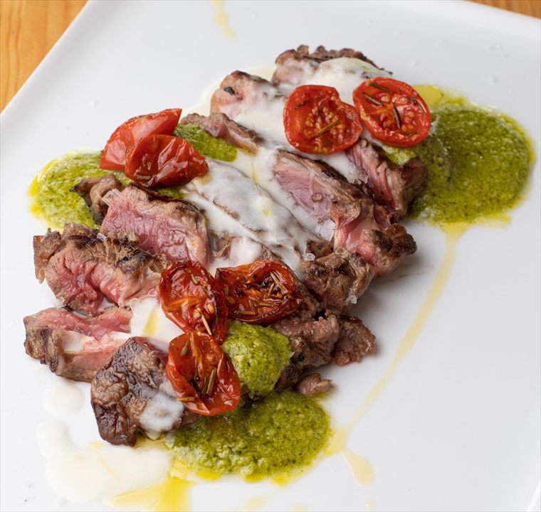 Tagliata di manzo con pomodorini confit, pesto e fonduta